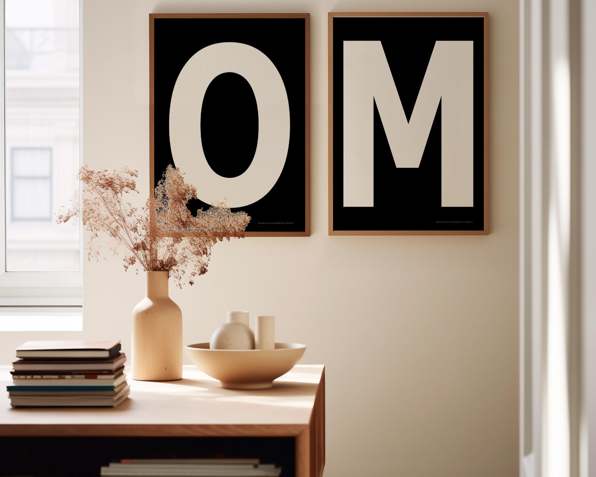 Two framed black and white letter art prints spelling out OM in a dining room.