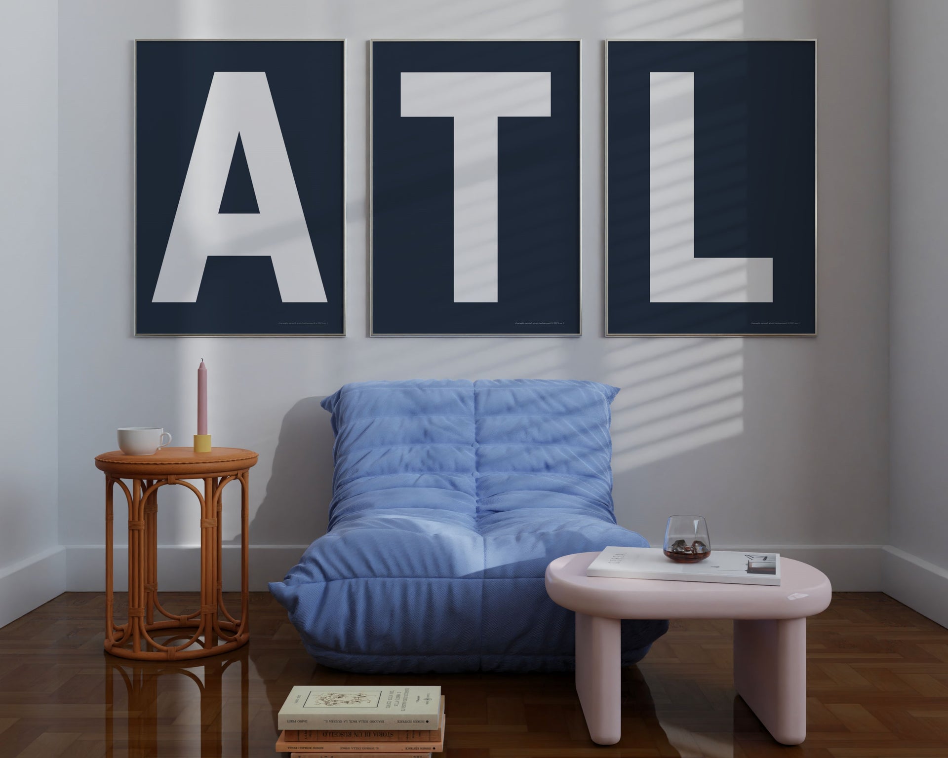 Three large framed navy blue and white letter art prints spelling out ATL hanging above a blue chair.