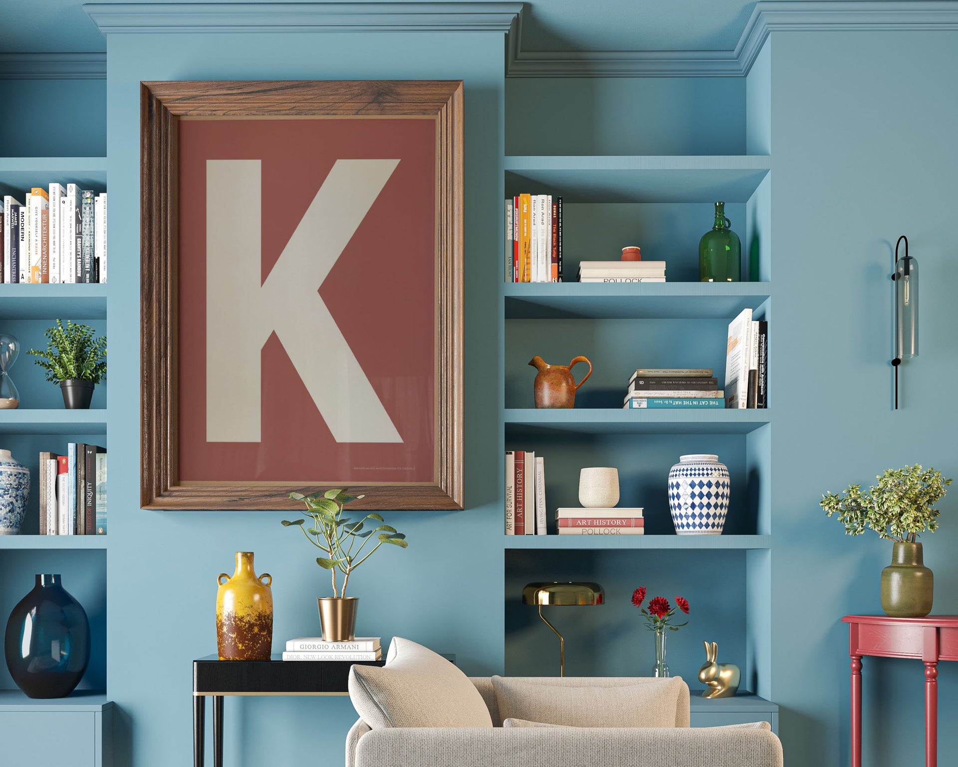 Large framed Nantucket red and white letter art print featuring the initial K hanging in a blue living room.