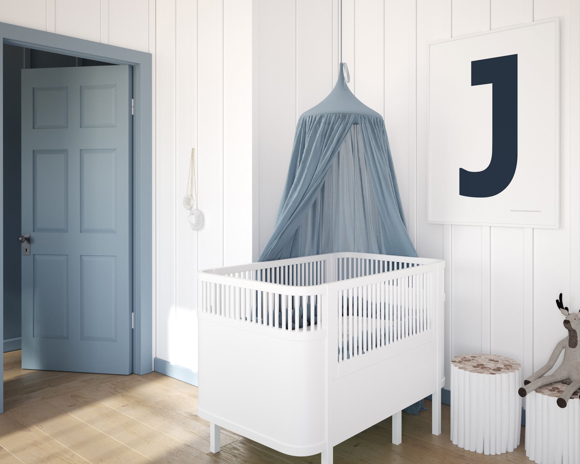 Framed navy blue and white letter art print featuring baby initial hanging over a white crib in a blue and white nursery.