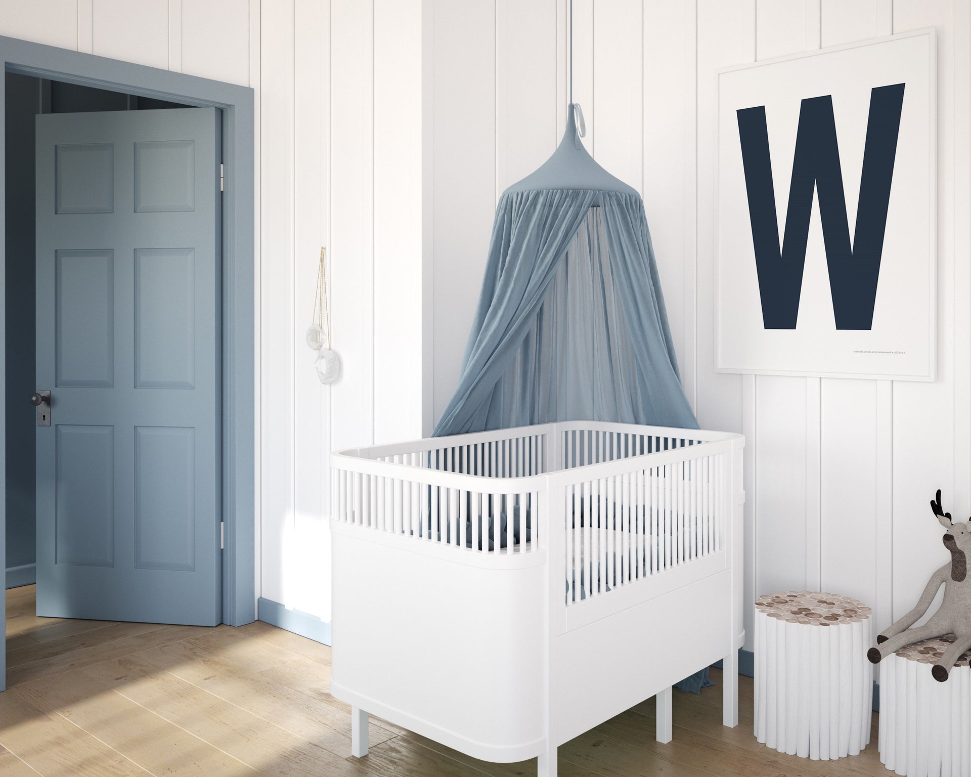 Framed navy blue and white letter art print featuring baby initial hanging over a white crib in a blue and white nursery.