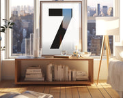 Framed white and black number art print in living room with a city view.