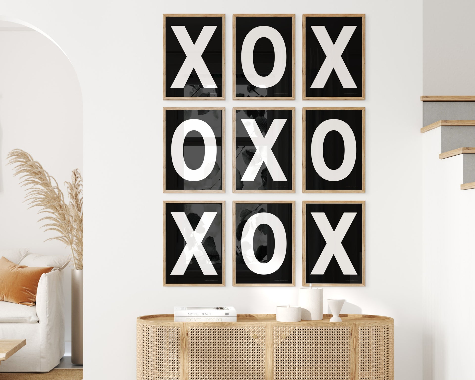 Nine framed black and white letter art prints featuring X and O creating tic tac toe on the wall.