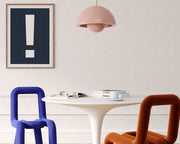 Framed navy blue and white exclamation point hanging on a wall in a modern dining room.