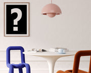 Framed black and white exclamation point haning on a wall in a modern dining room.