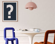 Framed navy blue and white exclamation point haning on a wall in a modern dining room.