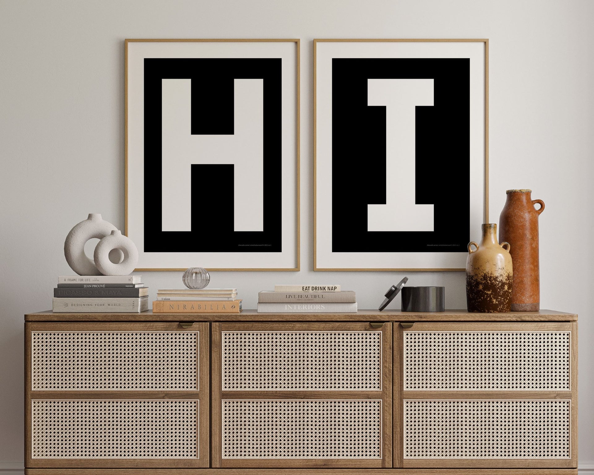 Two framed black and white letter art prints spelling out HI hanging above a credenza in a hallway or entryway.