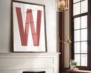 Oversized framed white and Nantucket red letter art print above a mantle in a living room.