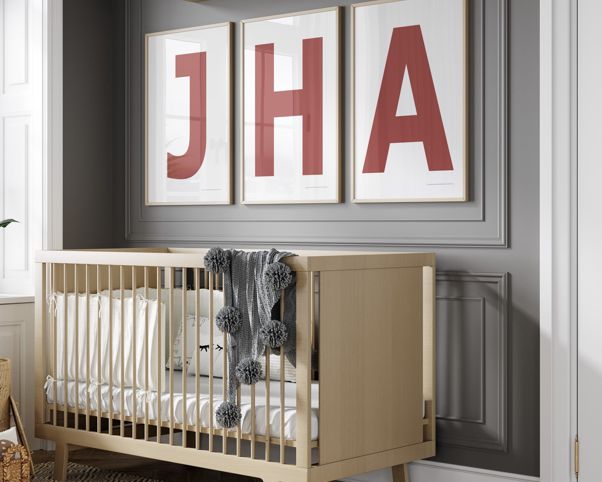 3 Framed letter art prints featuring Nantucket red and white initials hanging above a crib in a gray boy nursery.t hanging on the wall.