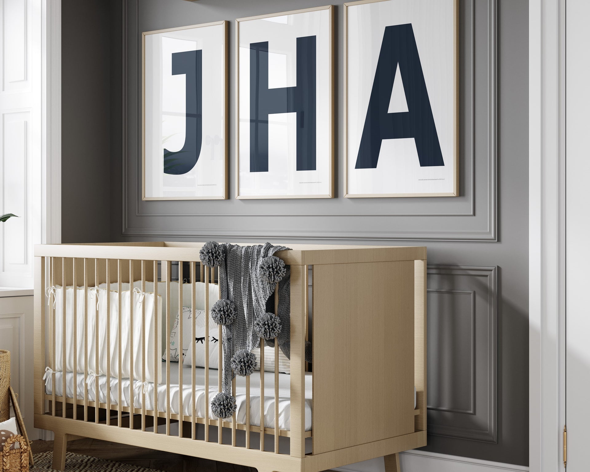 3 Framed letter art prints featuring navy blue and white initials hanging above a crib in a gray boy nursery.