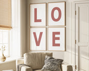 Four framed Nantucket red and white letter art prints spelling out LOVE hanging on wall in living room.