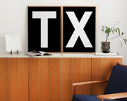 Two framed letter art prints spelling TX on a credenza.