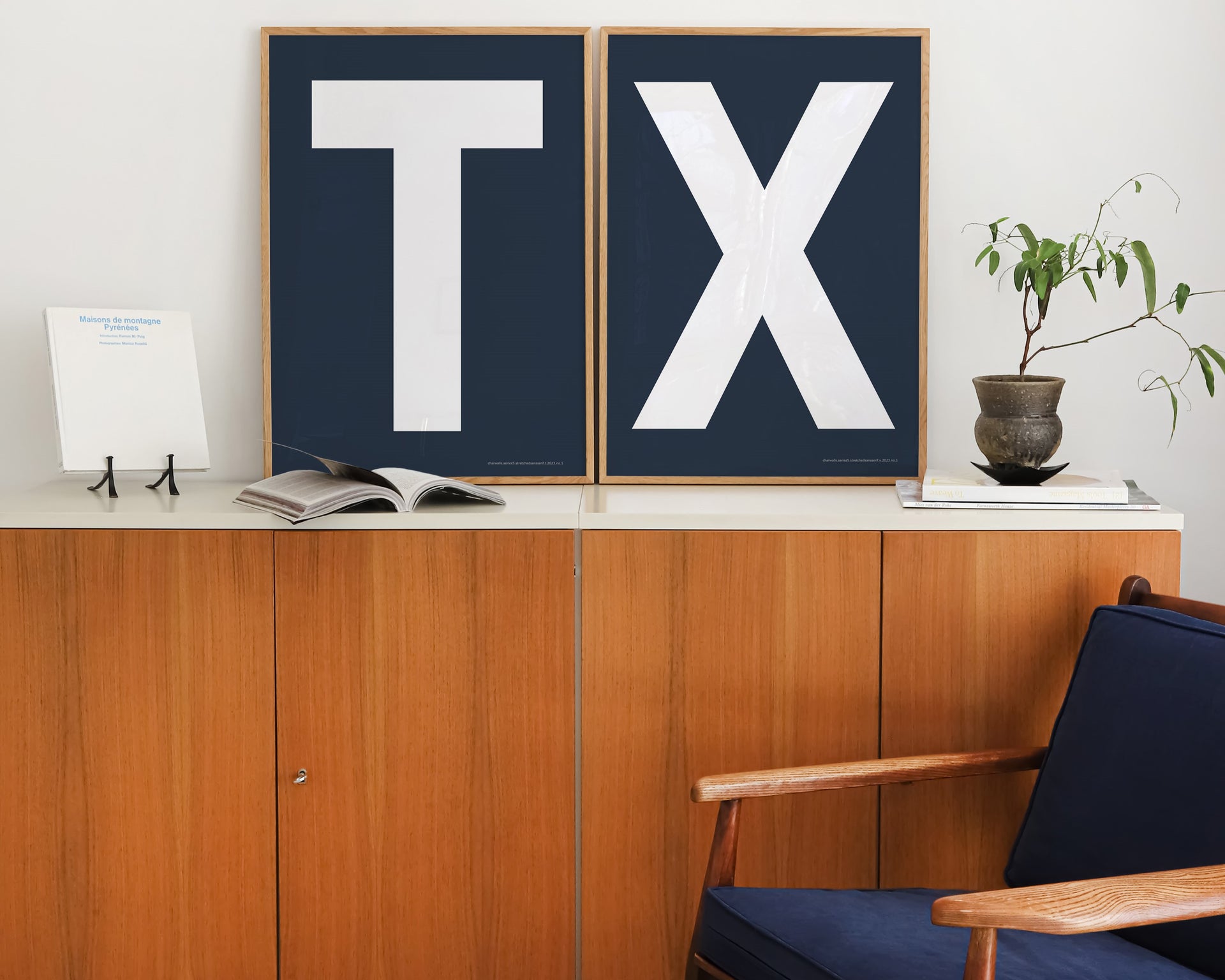 Two framed letter art prints spelling TX on a credenza