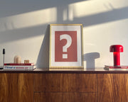 Small framed Nantucket red and white question mark art print on a midcentury credenza.