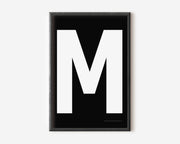 Modern art print with an uppercase white letter M on a black background.