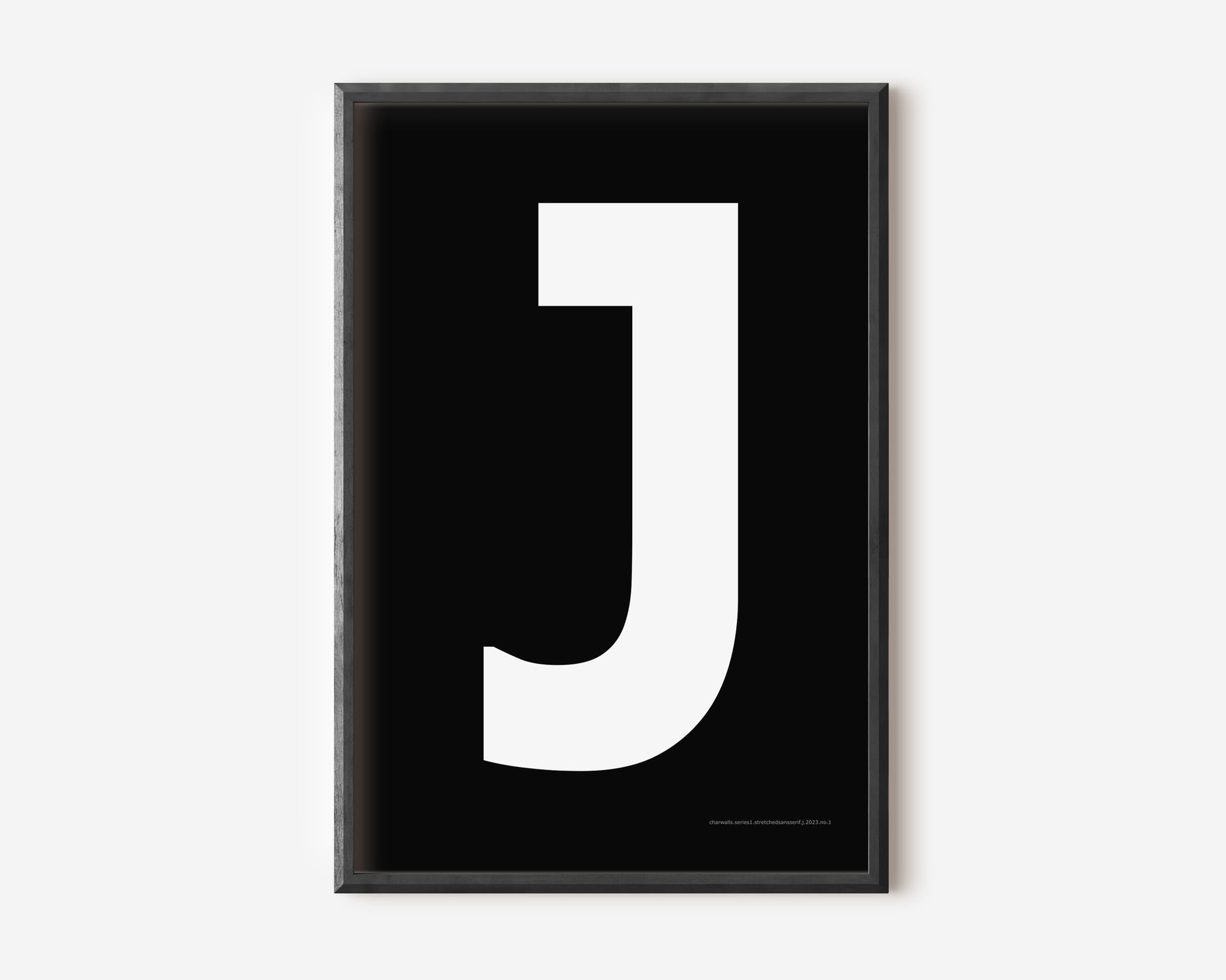 Modern art print with an uppercase white letter J on a black background.