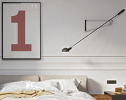 Framed Nantucket red and white number 1 art print hanging on a wall above a bed in a modern bedroom.