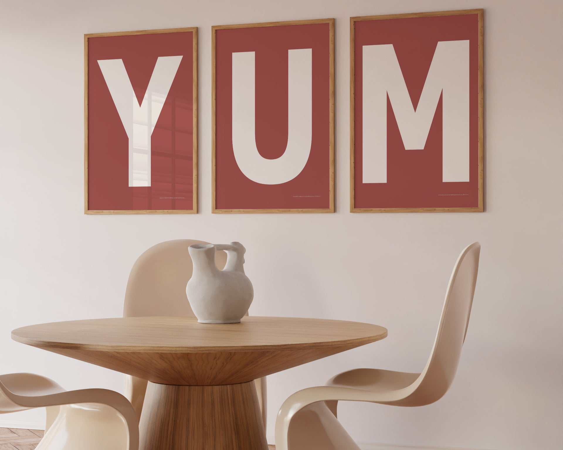 Three framed Nantucket red and white letter art prints spelling out the word YUM hanging in a modern dining room.
