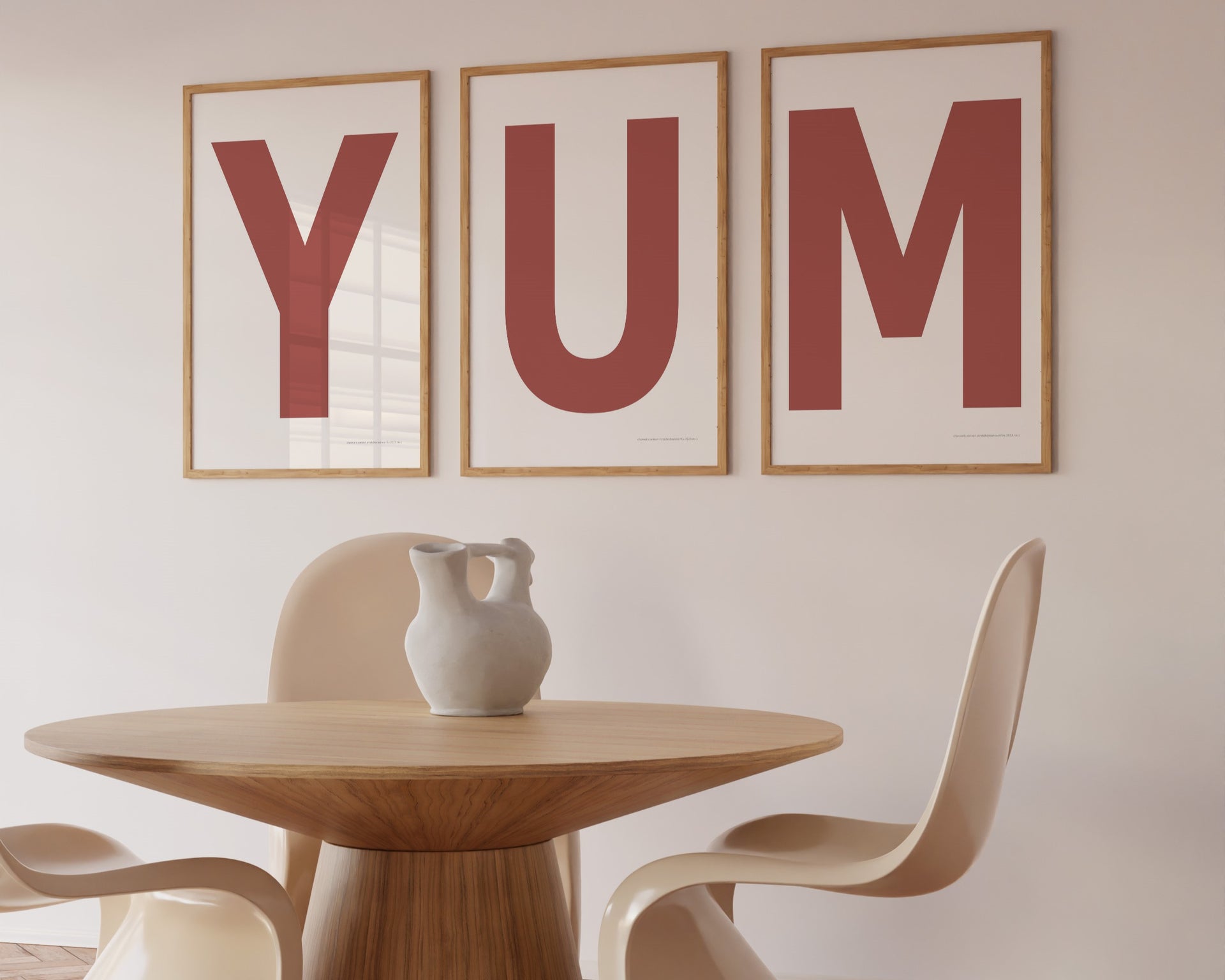 Three framed Nantucket red and white letter art prints spelling out the word YUM hanging in a modern dining room.