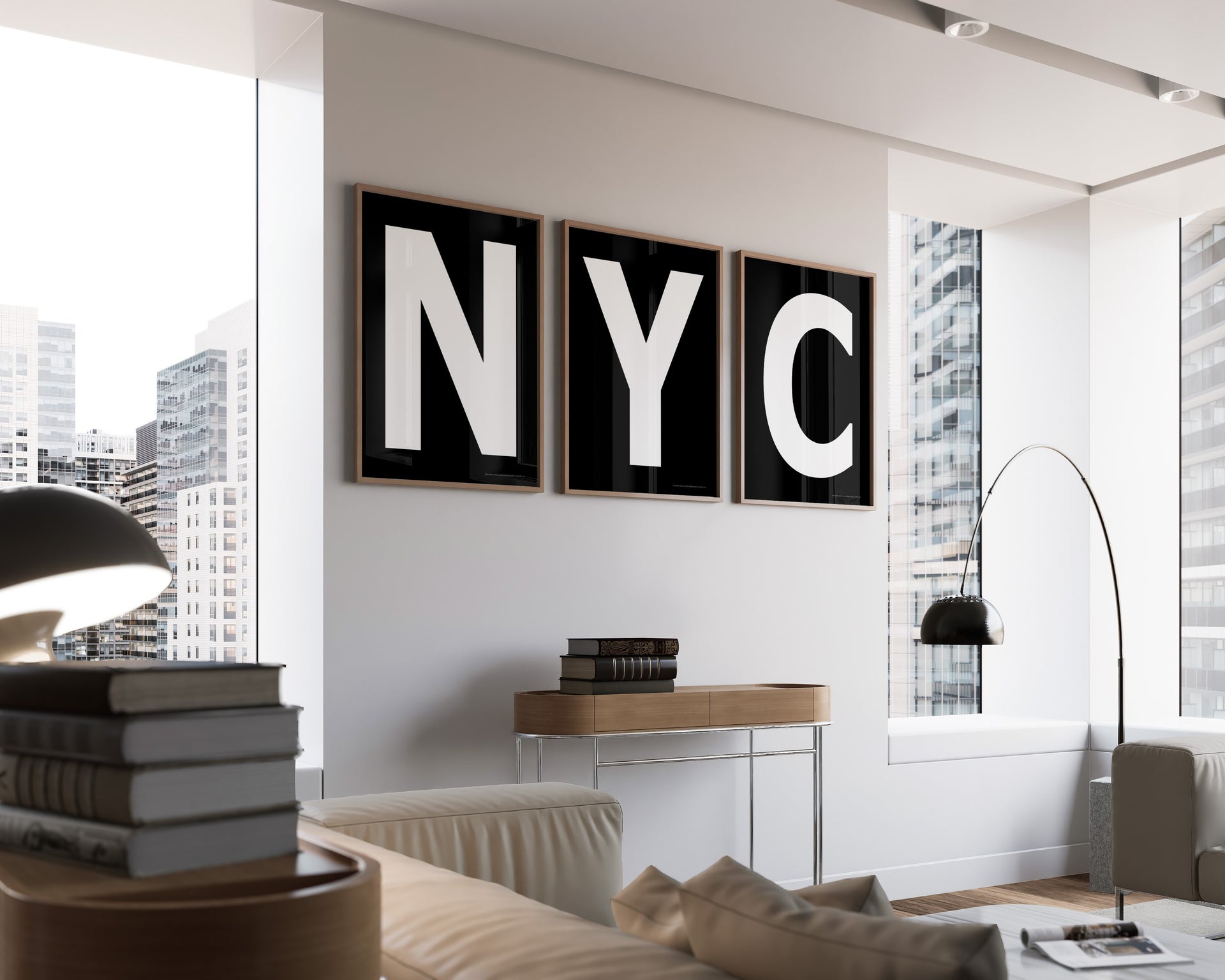 Three framed black and white letter art prints spelling out NYC hanging on a wall in a modern living room with a view of the city.