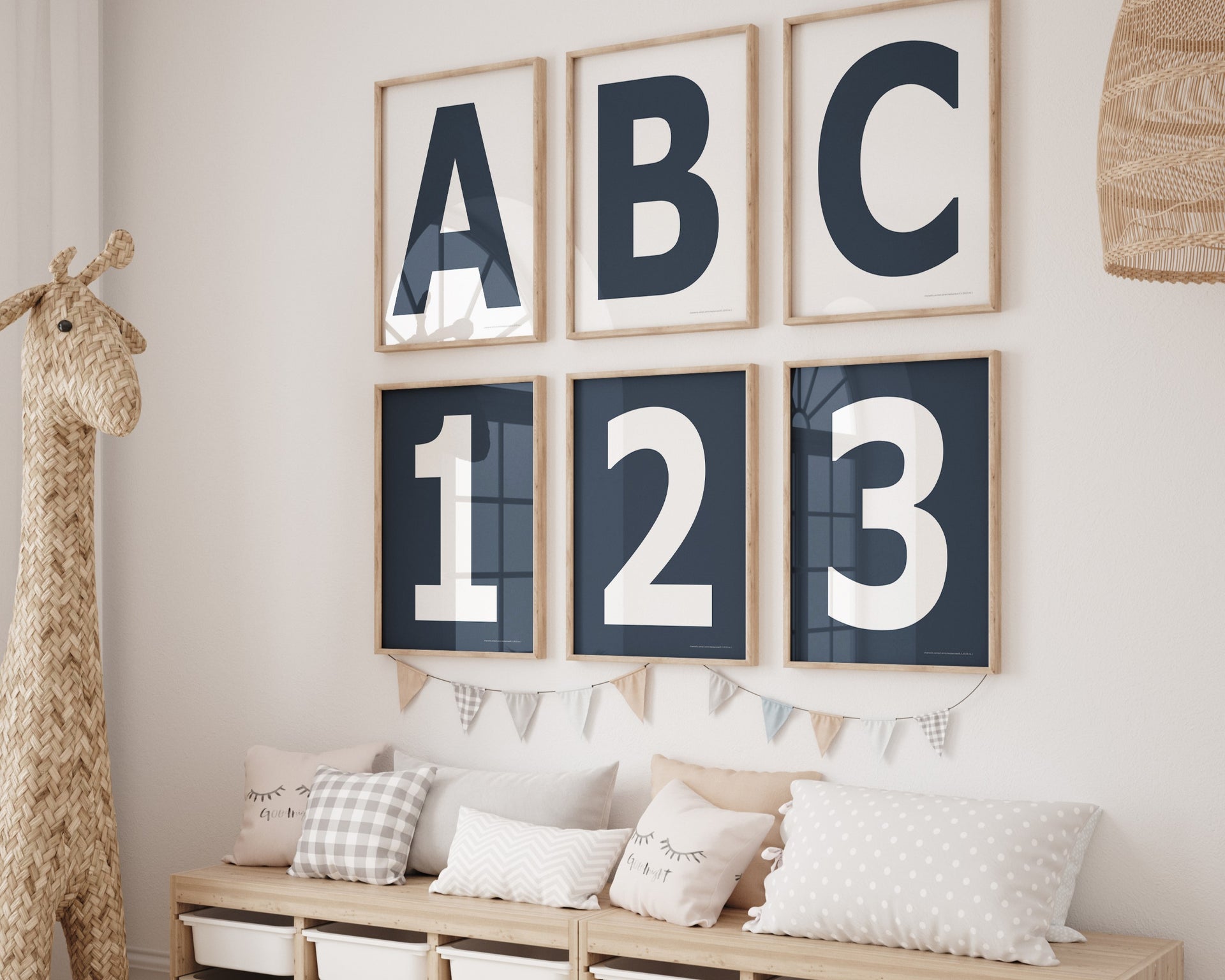 Six framed navy blue and white letter and number art prints spelling out ABC123 hanging on a wall in a nursery or playroom