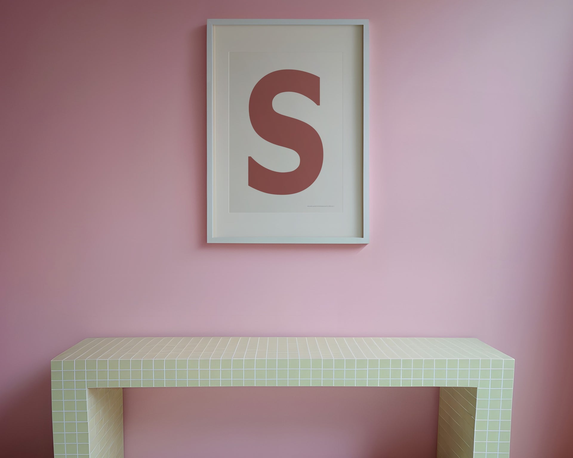 Framed letter art print in a funky pink entryway.
