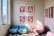 Framed letter art prints spelling out XO and XO in a modern reading nook with blue and pink chairs.