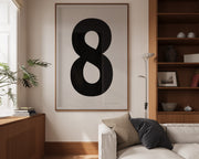 Oversized framed black and white number art print featuring the number 8 in a modern living room.