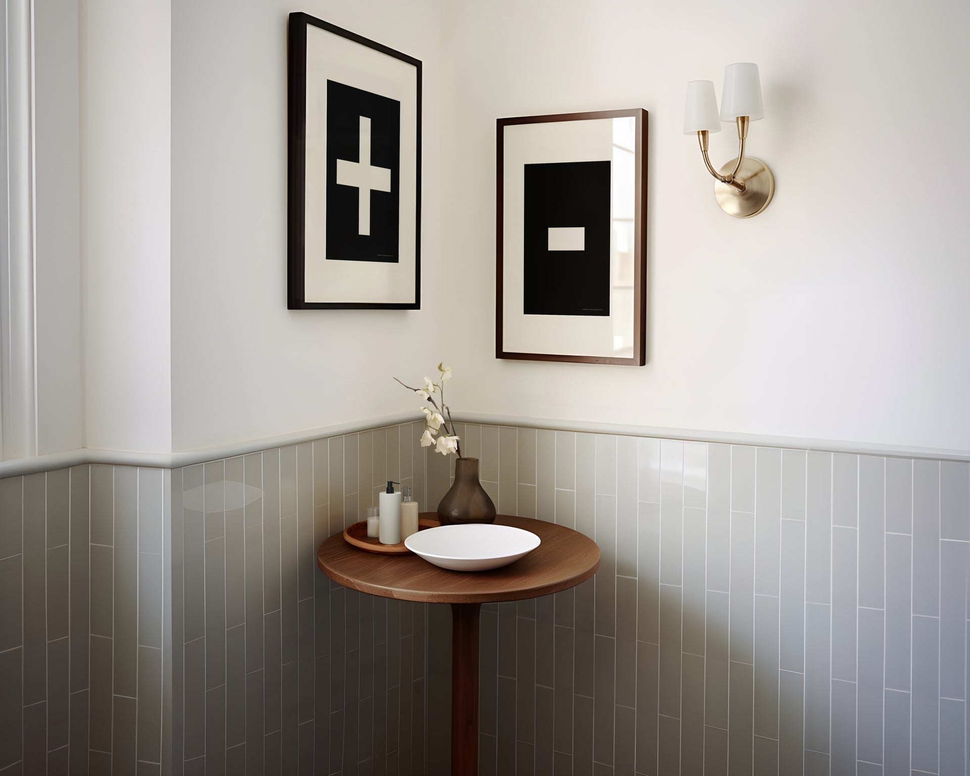 Two framed plus and minus art prints in a bathroom with green tile.