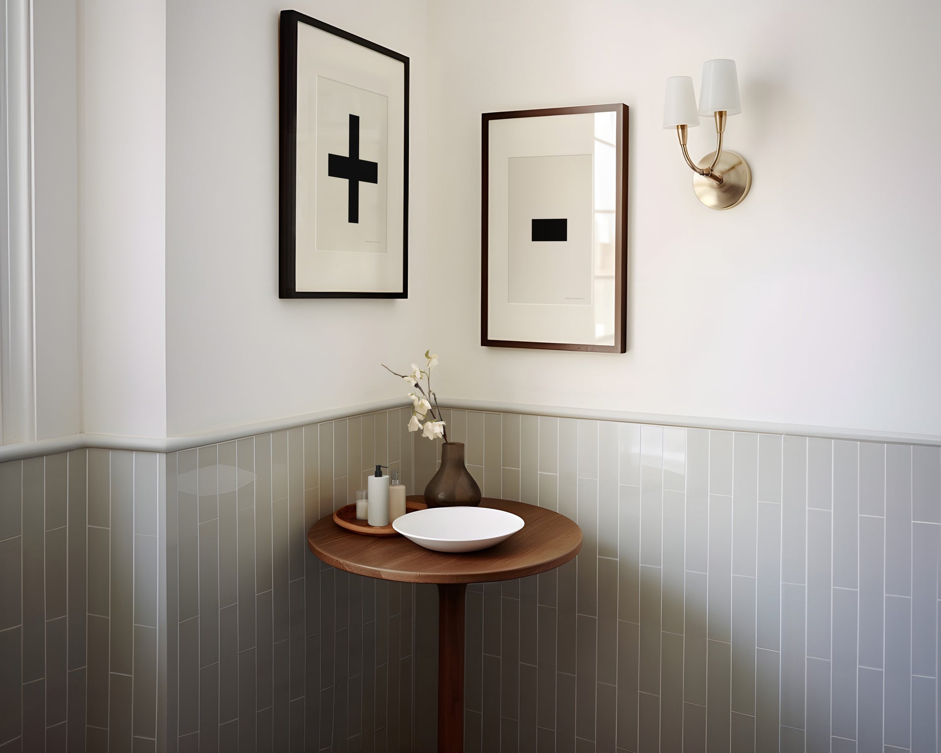 Two framed plus and minus art prints in a bathroom with green tile.