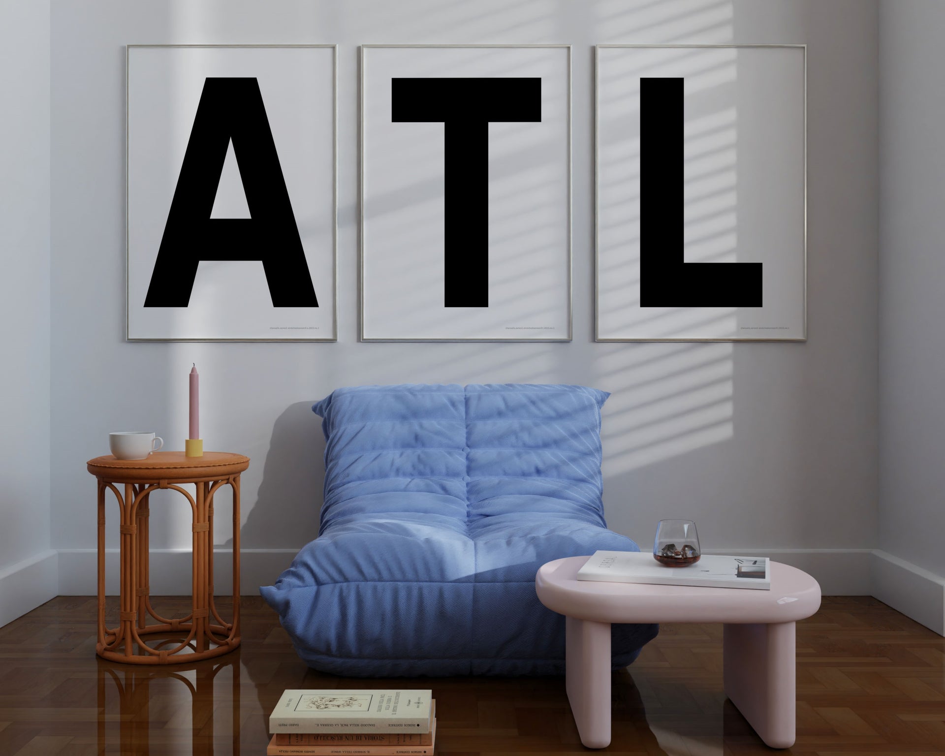 Three large framed black and white letter art prints spelling out ATL hanging above a blue chair.