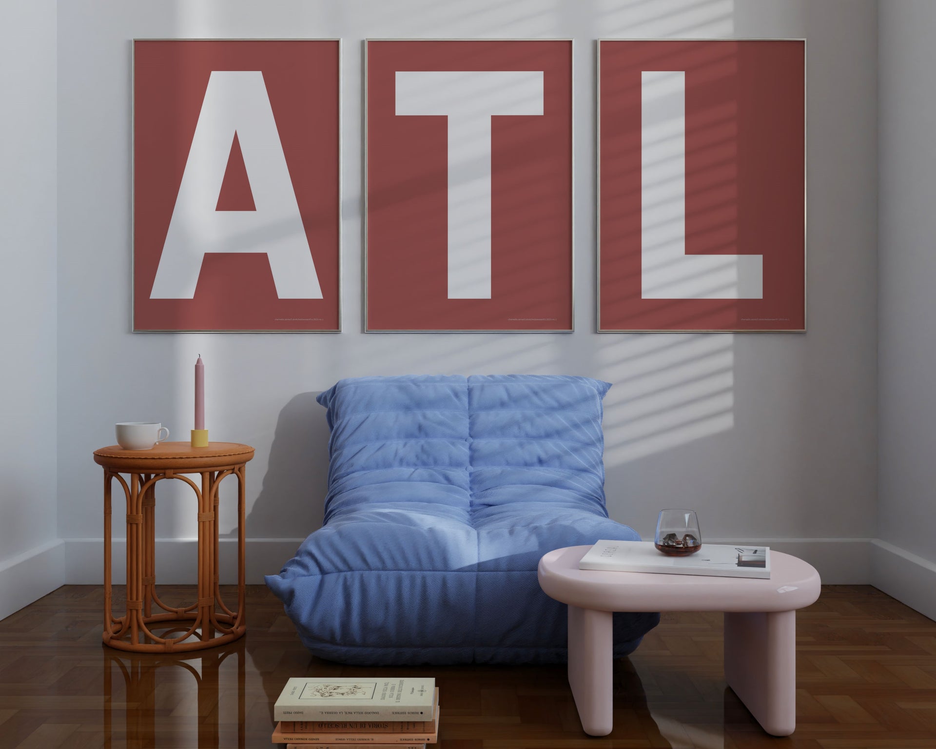 Three large framed Nantucked red and white letter art prints spelling out ATL hanging above a blue chair.