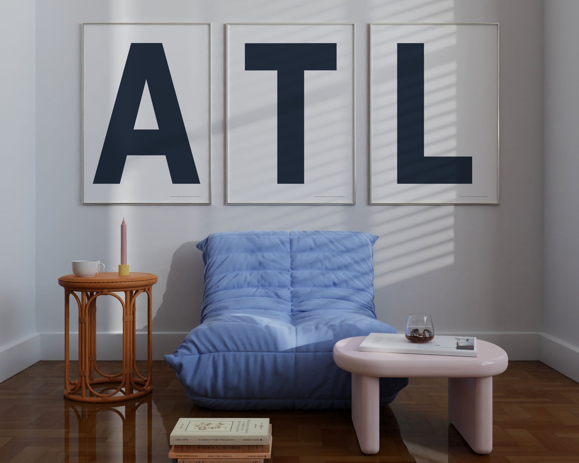 Three large framed navy blue and white letter art prints spelling out ATL hanging above a blue chair.