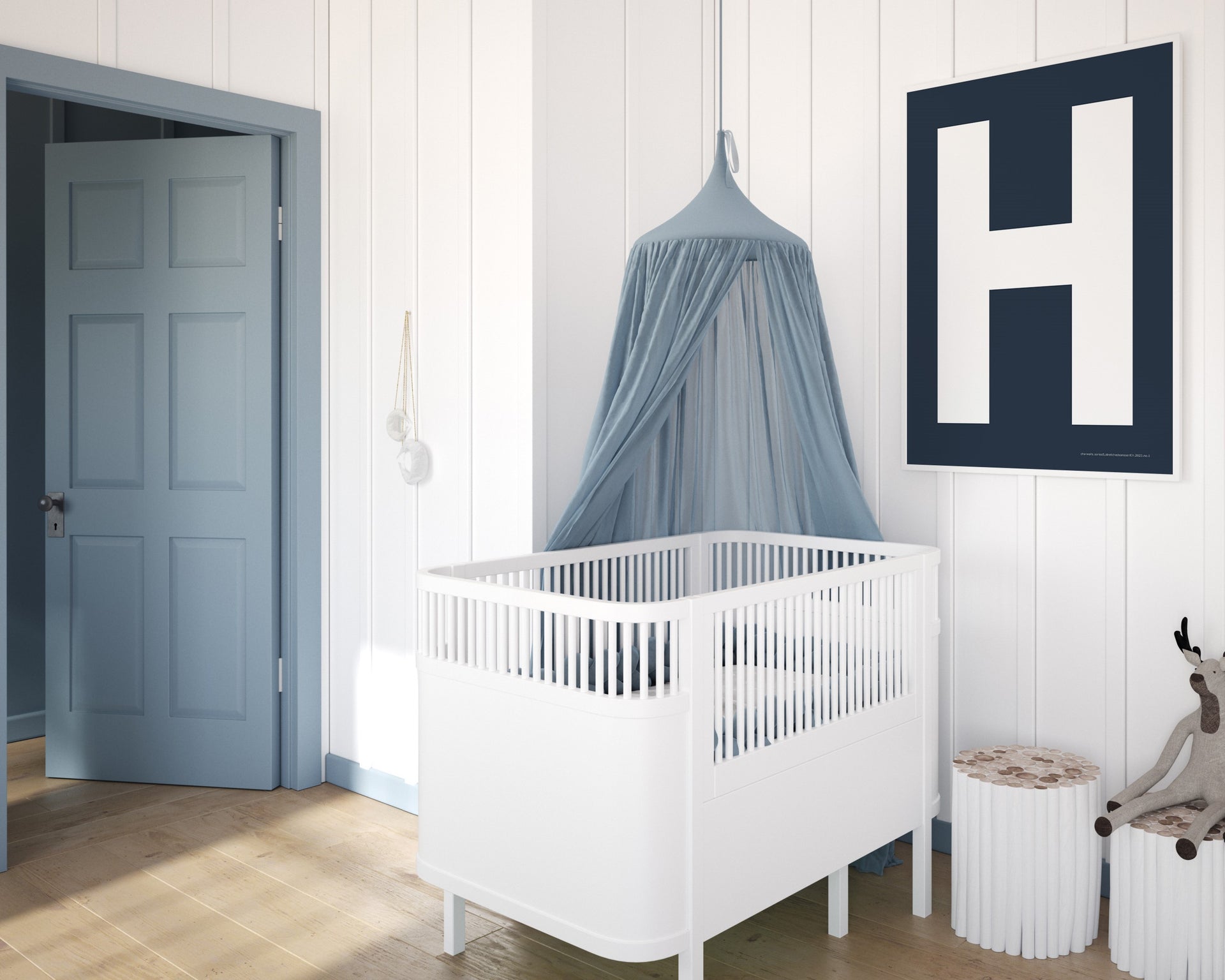 Framed navy blue and white letter art print featuring baby initial hanging over a white crib in a blue and white nursery.