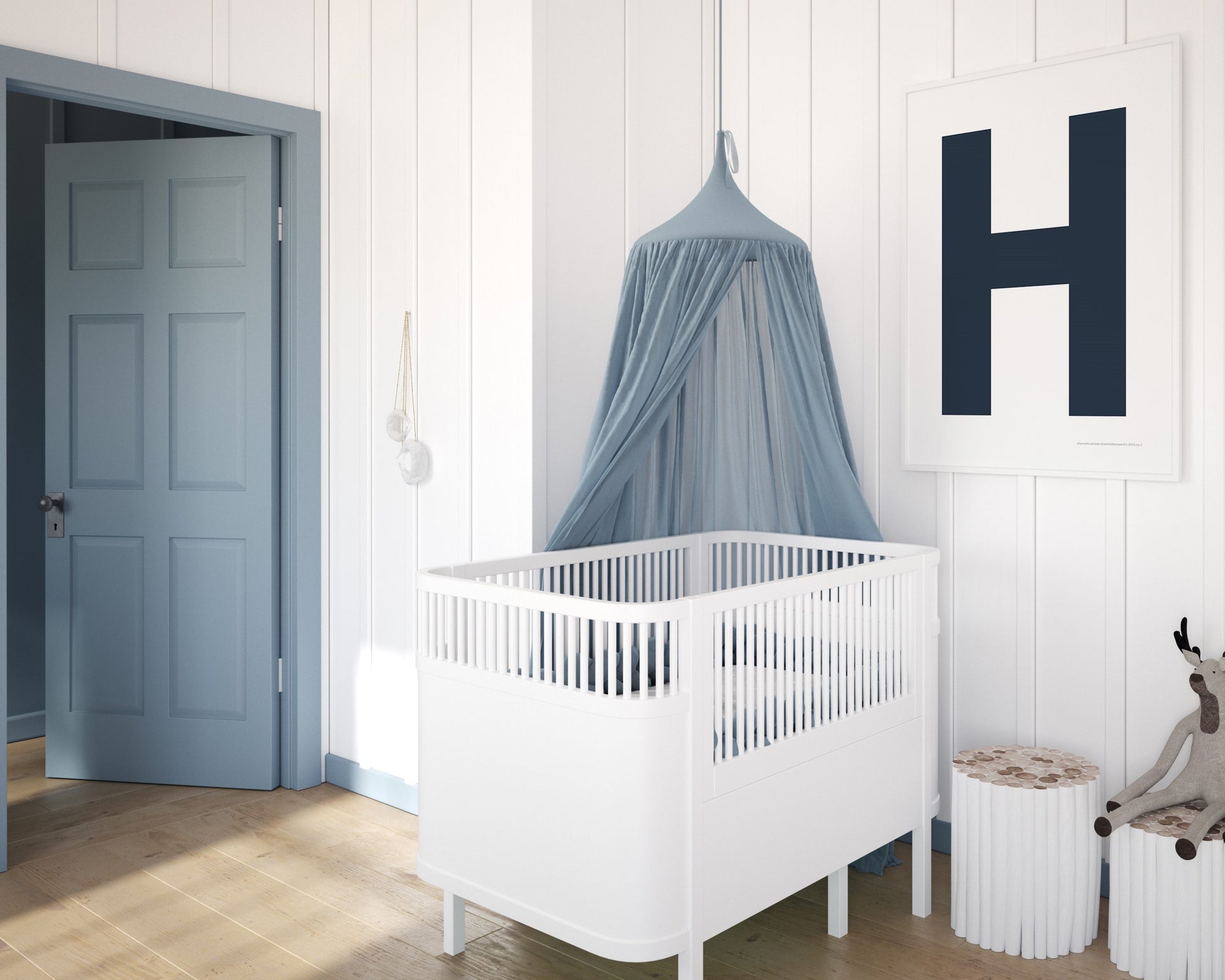 Framed navy blue and white letter art print featuring baby initial hanging over a white crib in a blue and white nursery.