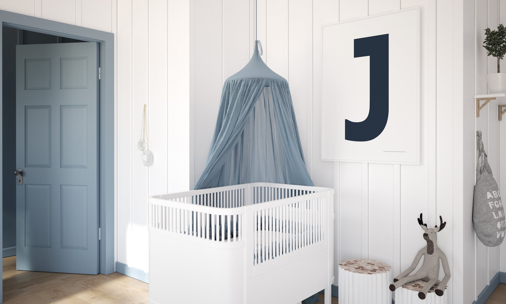 A modern blue and white nursery featuring a framed white and navy blue letter or initial J art print hanging above a white crib.