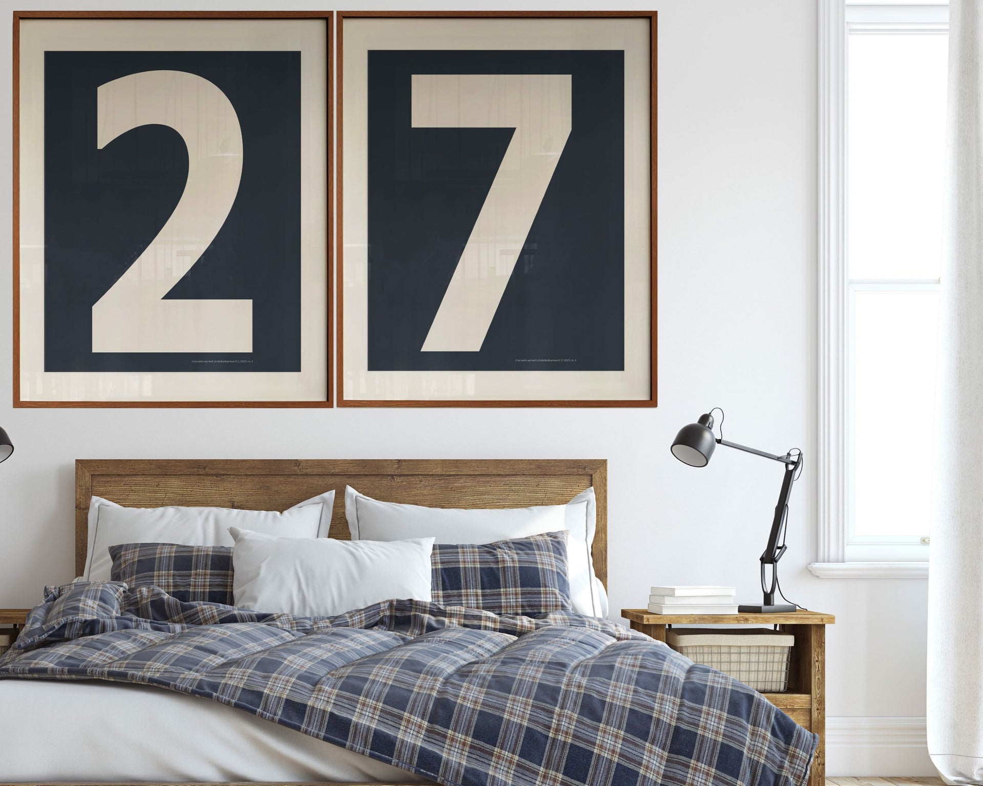 Two large framed navy blue and white number art frames showcasing a boy's jersey number hanging above his bed with a plaid blanket.