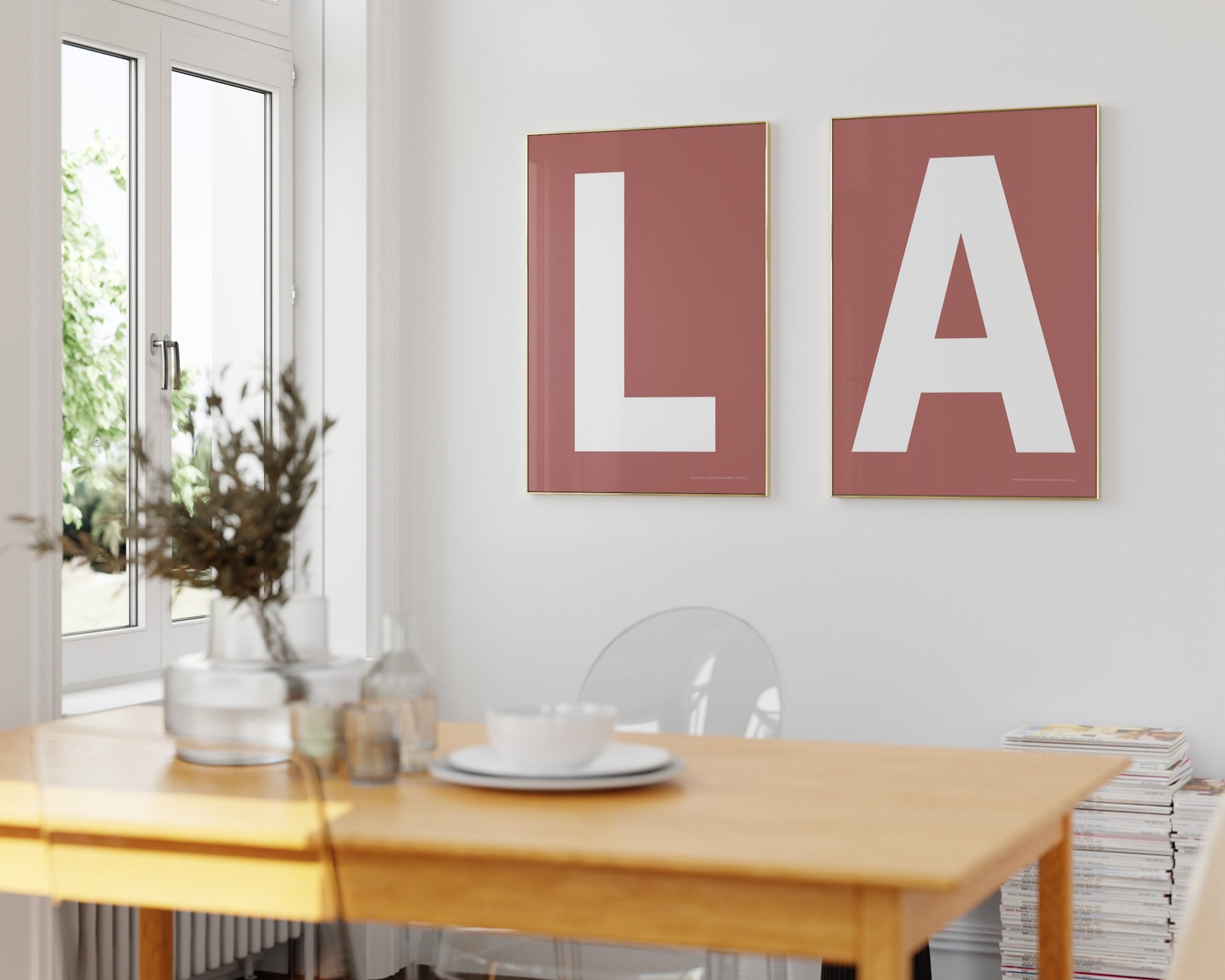 Two framed Nantucket red and white letter art prints spelling out LA hanging in a bright white dining room.