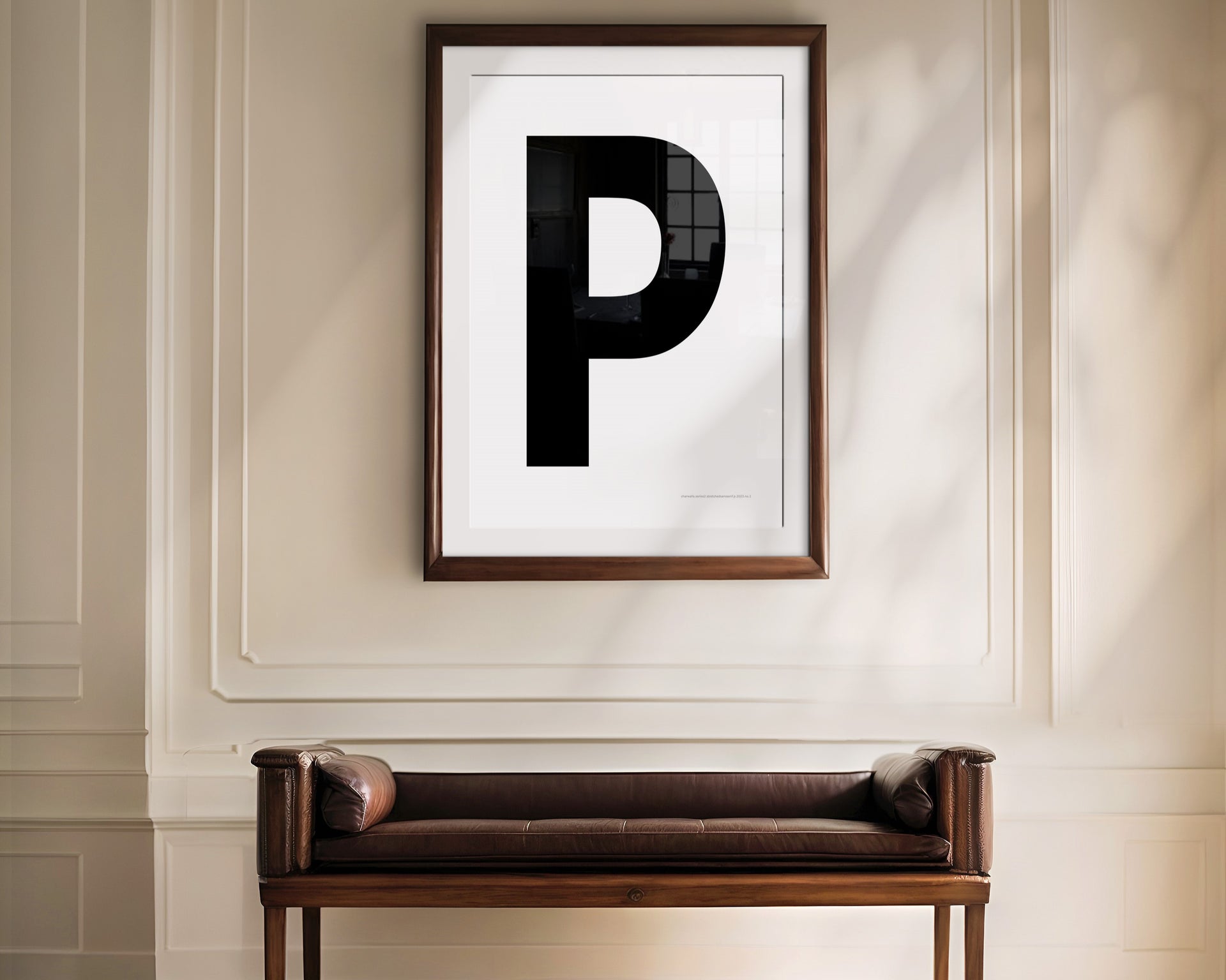 Oversized framed black and white letter art print haning above a bence in a formal entryway or hallway.