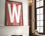 Oversized framed white and Nantucket red letter art print above a mantle in a living room.