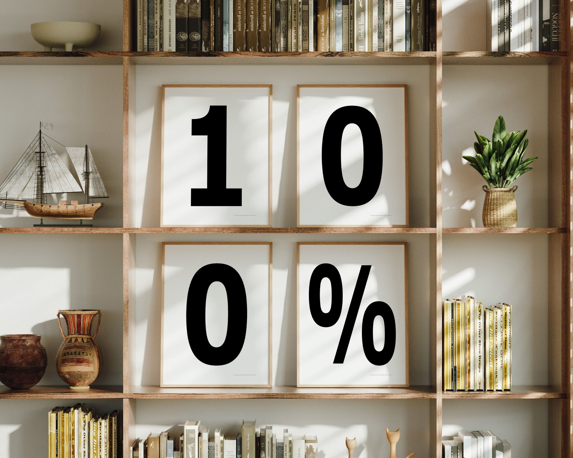 Four framed number and percent sign art prints spelling out 100% on a boho bookshelf.