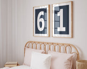 Two framed navy blue and white number frames featuring a girl's jersey numbers hanging above the bed.