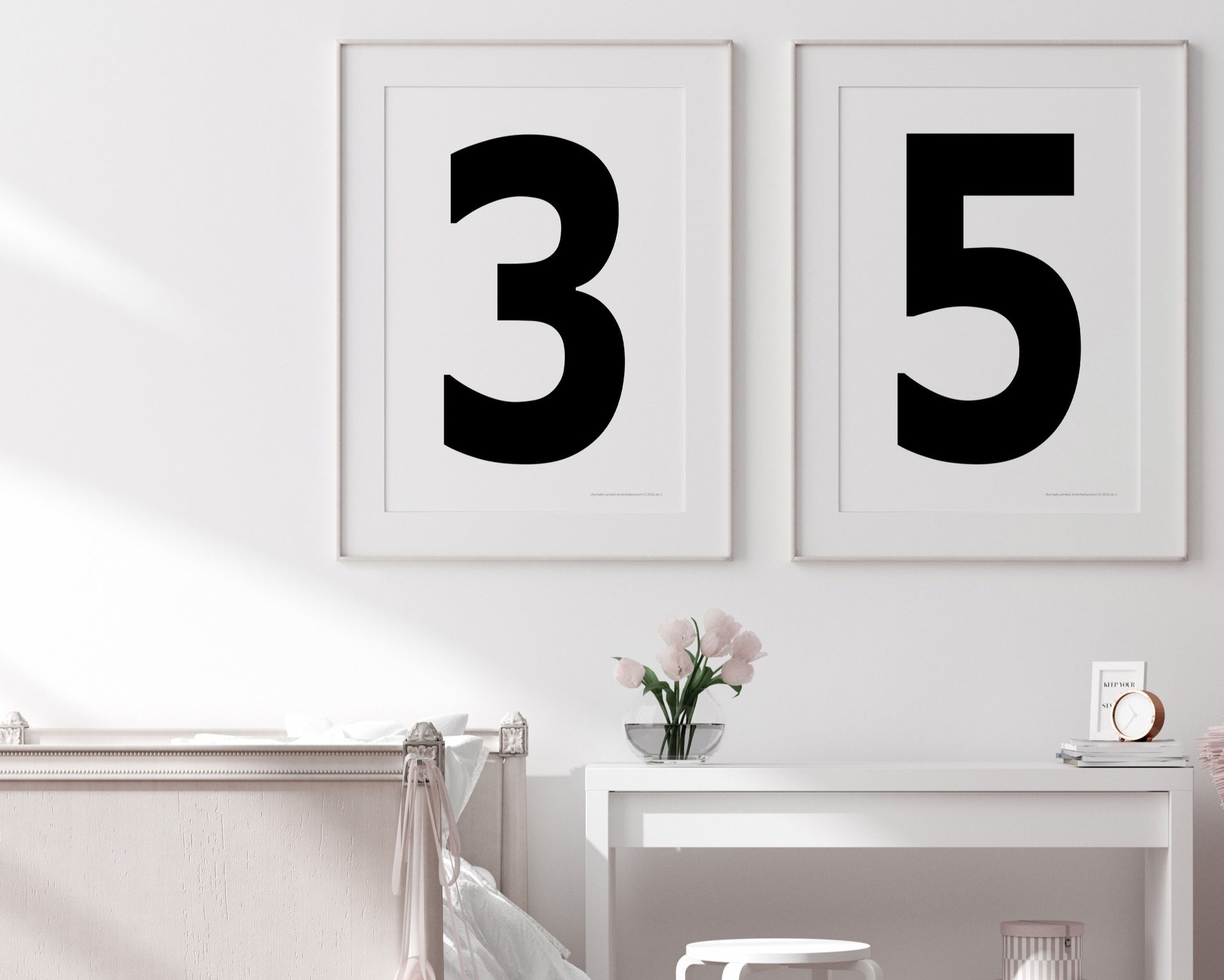 Two framed black and white number art prints showing a jersey number hanging above bed and desk.