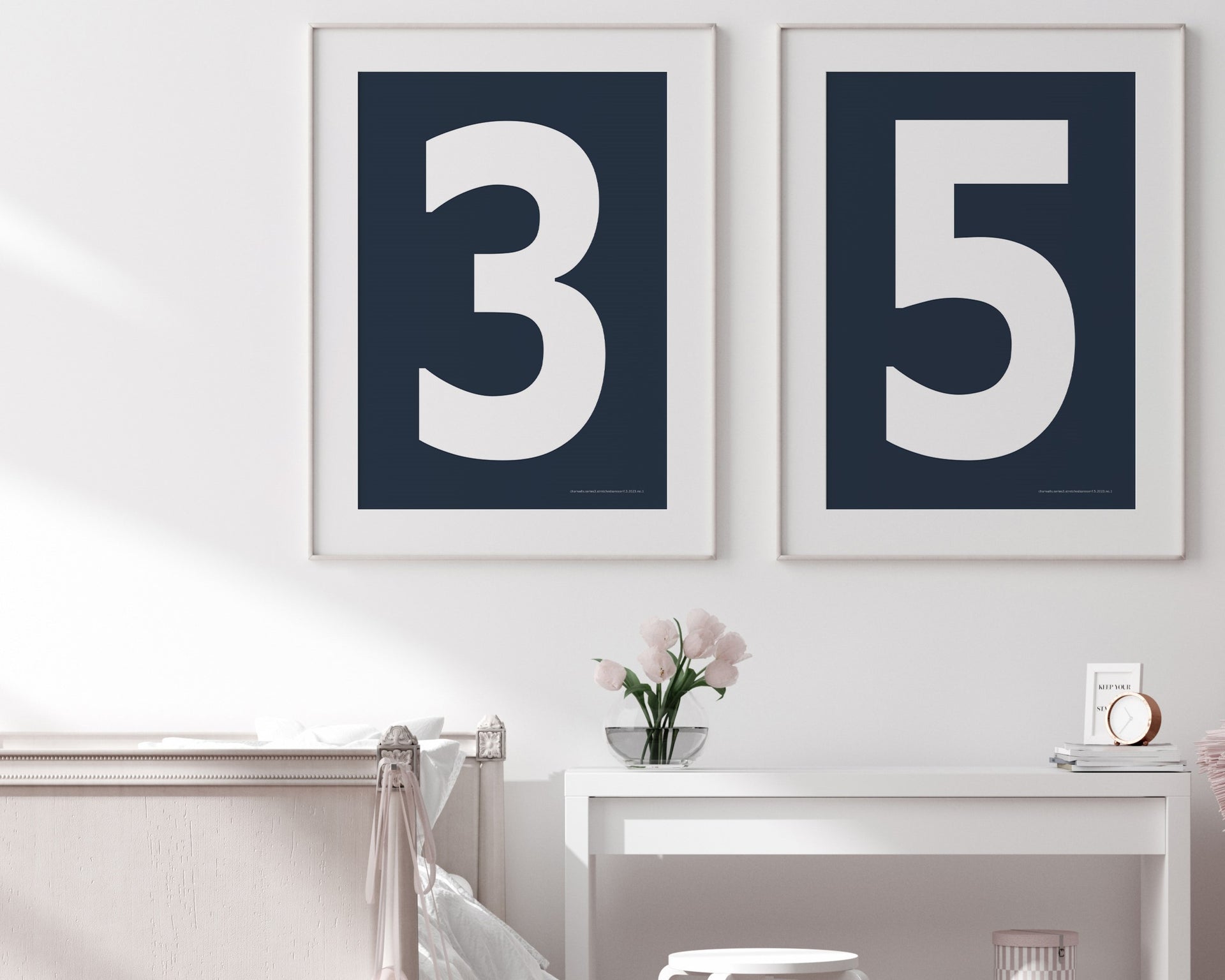 Two framed navy blue and white number art prints showing a jersey number hanging above bed and desk.