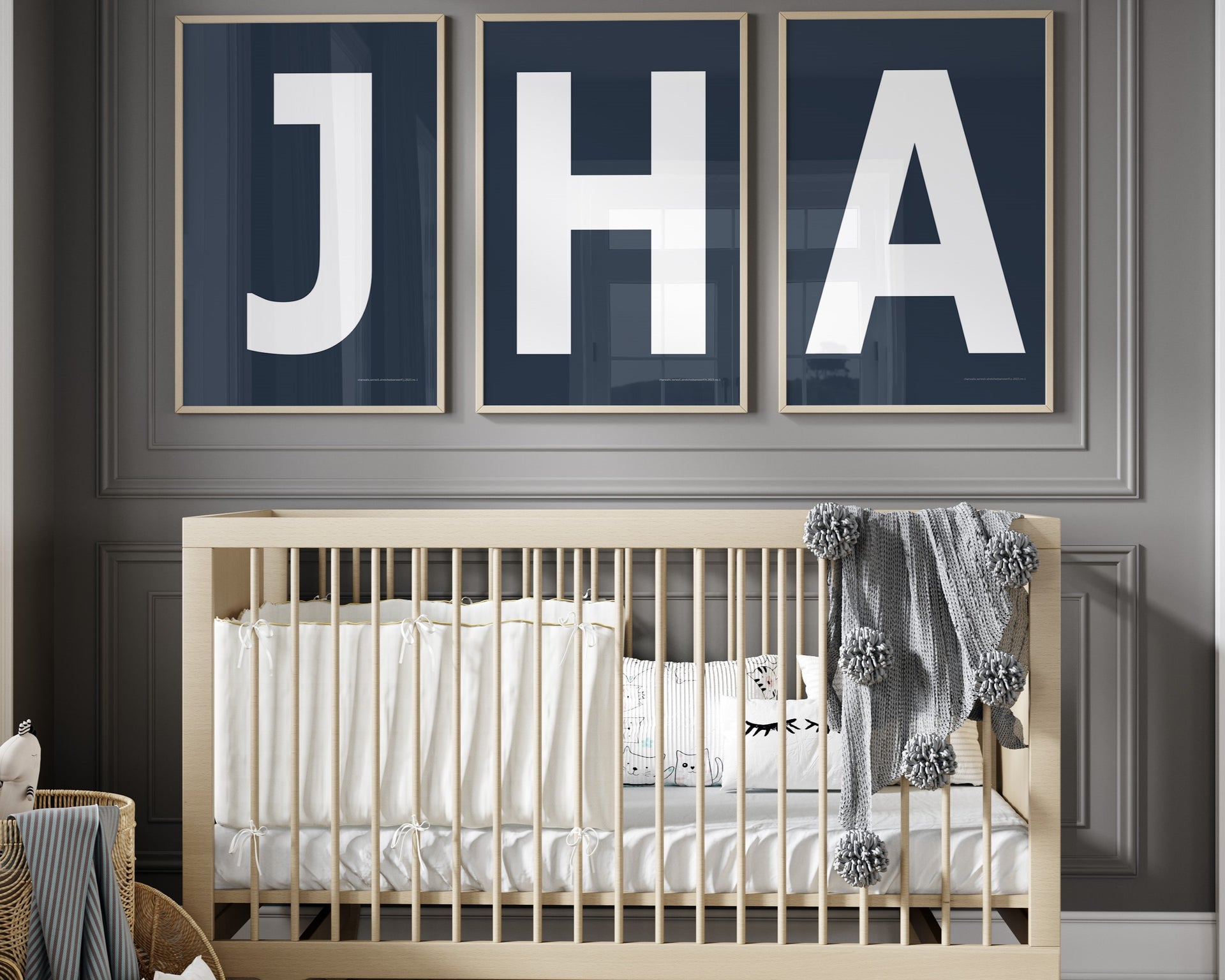 3 Framed letter art prints featuring navy blue and white initials hanging above a crib in a gray boy nursery.