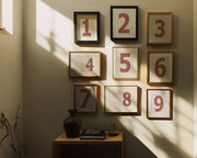 Nine small Nantucket red and white framed number art prints 1 through 9 in a hallway or entryway.