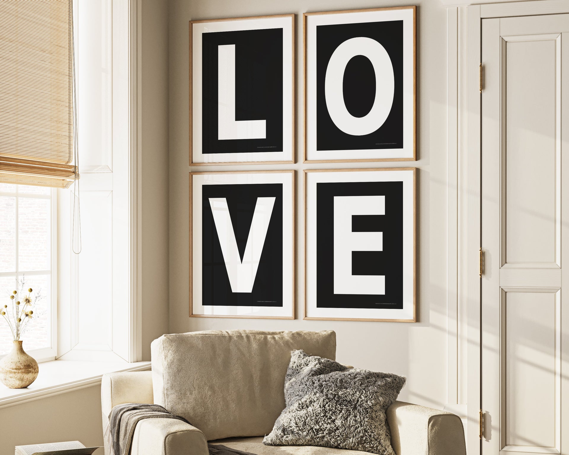 Four framed black and white letter art prints spelling out LOVE hanging on wall in living room.