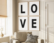 Four framed black and white letter art prints spelling out LOVE hanging on wall in living room.