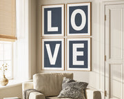 Four framed navy blue and white letter art prints spelling out LOVE hanging on wall in living room.