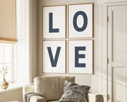 Four framed navy blue and white letter art prints spelling out LOVE hanging on wall in living room.